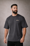 Man wearing subtle union a faded black t-shirt with 'here' text on a gray background